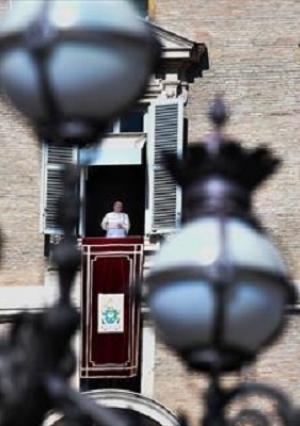 البابا فرانسيس يلوح للمصلين من نافذة القصر الرسولي المطل على ساحة القديس بطرس أثناء صلاة الملاك الأسبوعية