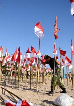 طلاب يرفعون الأعلام الإندونيسية على شاطيء في جزيرة بالي