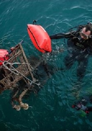 متطوعون من منظمة يونانية يقومون بتنظيف شاطئ بحر إيجه من النفايات البلاستيكية  في ميناء جزيرة زاكينثوس
