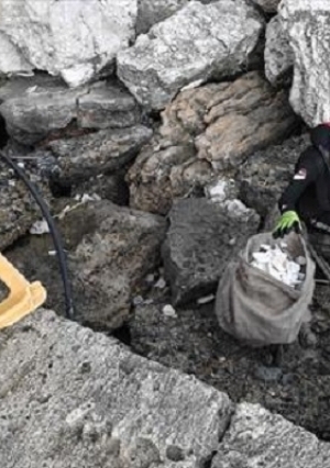 متطوعون من منظمة يونانية يقومون بتنظيف شاطئ بحر إيجه من النفايات البلاستيكية  في ميناء جزيرة زاكينثوس