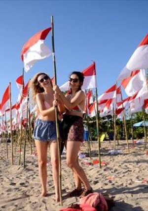 طلاب يرفعون الأعلام الإندونيسية على شاطيء في جزيرة بالي