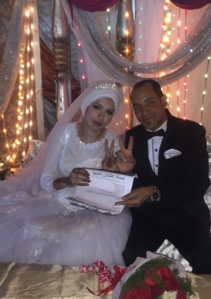 بالصور| عروسان يوقعان على استمارة" عشان تبنيها
