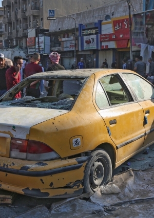 عراقيون يتفقدون موقع انفجار عبوة قرب ساحة التحرير وسط بغداد