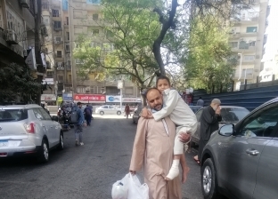 أب يحمل ابنه في رحلة يومية من أطفيح للقاهرة: معاناة بدأت بـ«كيس دهني»