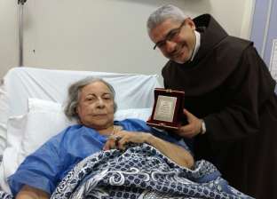 بالصور| الأب بطرس دانيال يُكرم آمال فريد بعد تعافيها بأحد المستشفيات