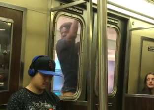 "فيديو مرعب".. شاب يعبر محطتين مُعلقا في باب المترو