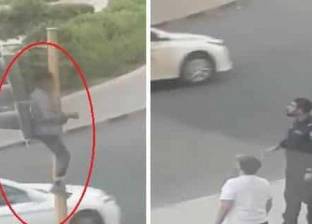 بالفيديو| مخمور يتسلق إشارة مرور بالكويت والشرطة تحاول إقناعه بالنزول