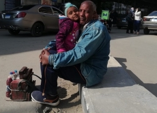 عامل ورنيش بالدقي يحمل طفلته أثناء العمل.. «خالد»: بجهز بنتي الكبيرة