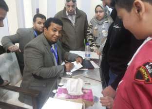 "إسماعيل" خطاط يكتب أسماء زوار معرض الكتاب على البطاقات