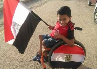 «كريم» زين كرسيه «المتحرك» بأعلام مصر لتشجيع المنتخب باستاد برج العرب