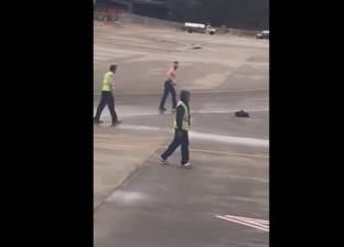 بالفيديو| رجل "نصف عار" يقاتل عمال مطار في مشهد غريب