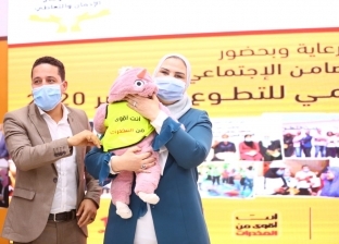 وزيرة التضامن تداعب طفلة خلال احتفالية اليوم العالمي للتطوع