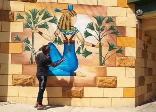 «رسام المنوفية» يزين مدينة تلا بجدارية مستوحاة من العصر الفرعوني