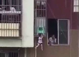 بالفيديو| مشهد مرعب لطفل يتدلى من شرفة بالطابق الثالث وعنقه بين الحديد