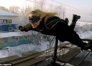 بالصور| على طريقة "بات مان".. روسية تمارس التزلج على أسطح القطارات