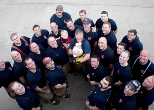 رجال إطفاء أمريكيون في جلسة تصوير مع طفلة زميلهم المتوفى
