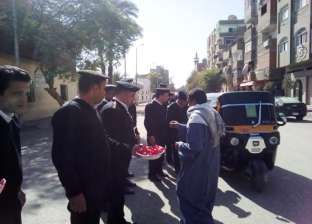 رجال الأمن يوزعون الشيكولاتة احتفالا بعيد الشرطة في أسوان