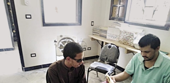 أحد المتطوعين في جلسة قراءة لكفيف