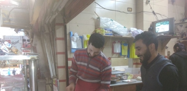 أحد العمال أثناء إعداد ساندوتشات الفول للزبائن