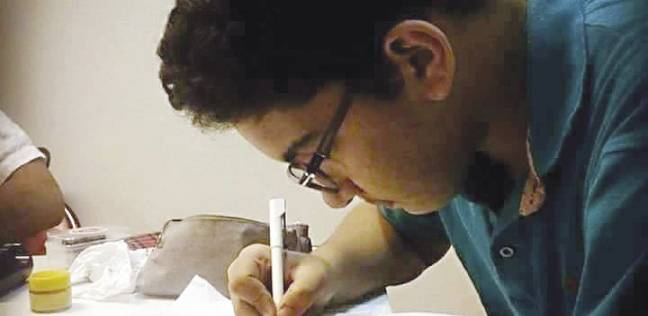 «عمر» يكتب إحدى لوحاته