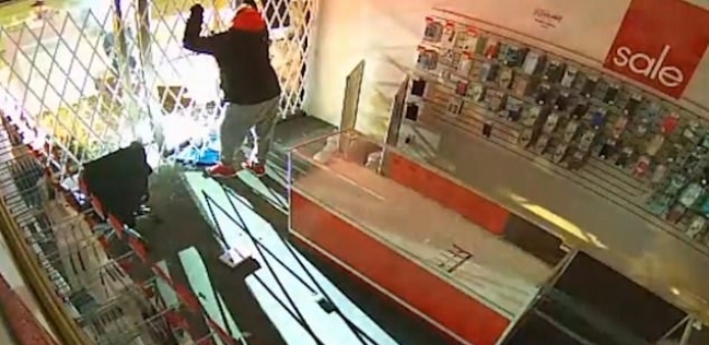 لقطة من تسجيل كاميرا المراقبة لمحاولات اللص الخروج من المحل
