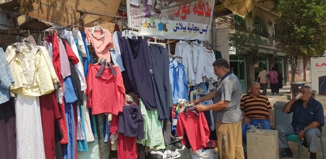 «أحمد» يعرض ملابسه مجاناً فى الشارع
