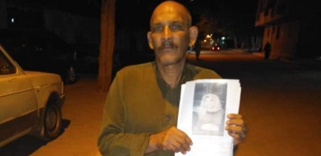 «خالد» يحمل صورة ابنته «هاجر»