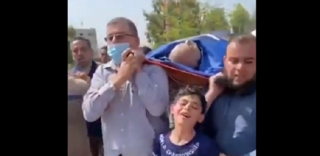 طفل فلسطيني يودع والده الشهيد بسبب القصف الإسرائيلي في مشهد مبكي