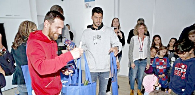 ميسي وسواريز لاعبا برشلونة أثناء توزيعهم للهدايا