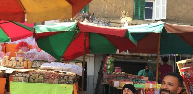 «أم على» أمام فرشتها لبيع حلاوة المولد