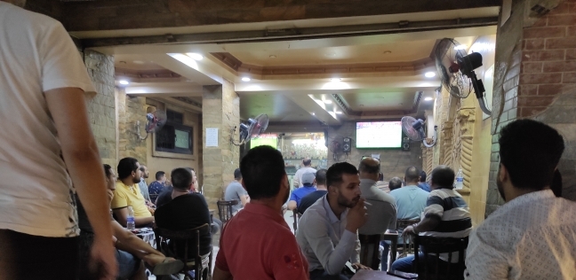 مواطنون يتابعون المباراة في مقهى بشارع فيصل