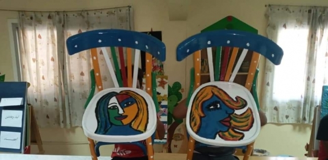 أطفال دار أيتام يرسمون على الكراسي الخشبية