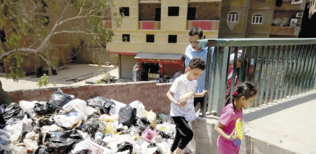 أطفال يحاولون العبور فوق القمامة
