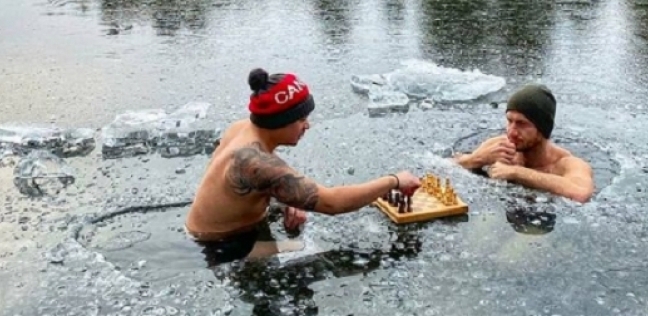 رجلان يلعبان الشطرنج في بحيرة جليدية
