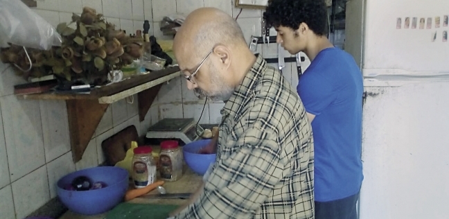 محمد عطا الله فى المطعم وبجواره ابنه يساعده
