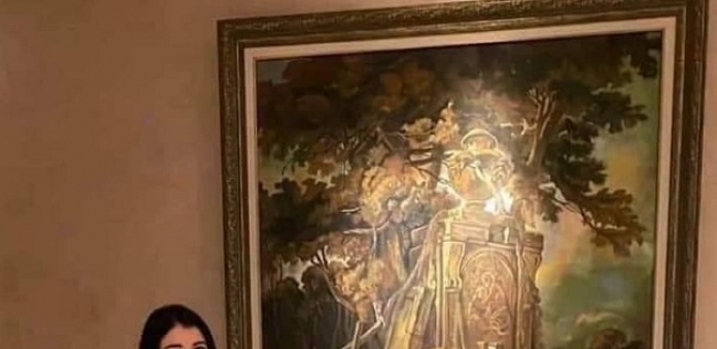 الطالبة نيرة أشرف بجوار اللوحة