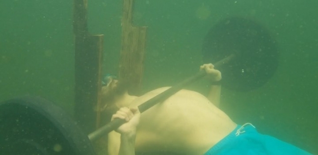 روسي يرفع أثقال تحت الماء
