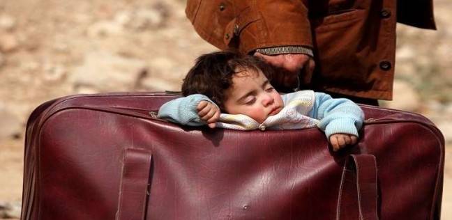 طفل نائم داخل حقيبة سفر والده في بيت سوا أثناء مغادرة الغوطة