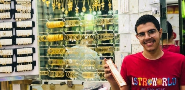 الطالب علي يونس مع الهدية داخل محل المجوهرات