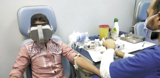 طفل مريض أثناء سحب عينة دم مرتدياً نظارة «VR»