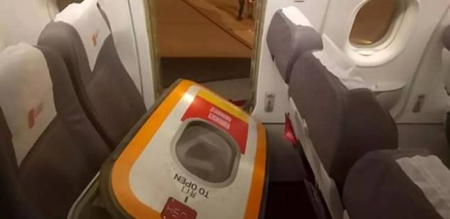 رجل يفتح باب الطوارئ في طائرة