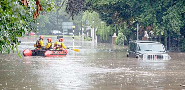 عمال الانقاذ في قارب بشارع مغمور بالمياه في مدينة "مانشستر" الإنجليزية