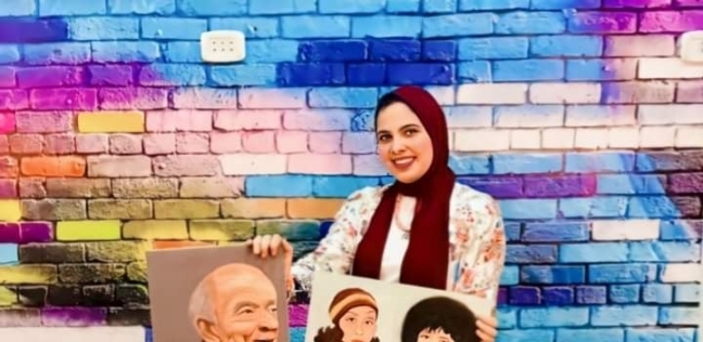 الطالبة سلسبيل حسين إلى جوار رسوماتها