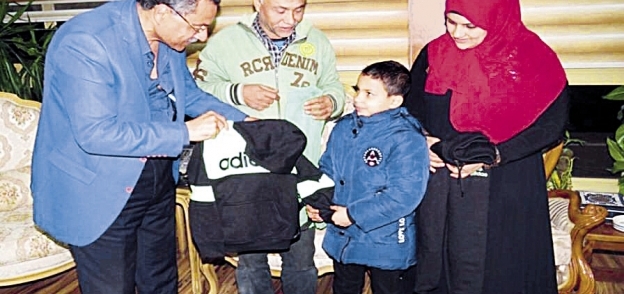 «الطفل الحافى» أثناء تسلمه الحقيبة من مدير الأمن
