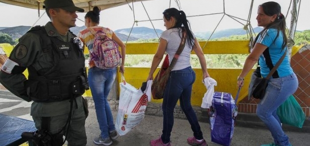 نساء يعبرن الحدود بين فنزويلا وكولومبيا