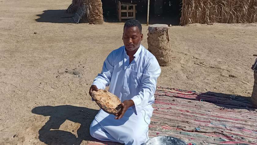 منصور سعيد من سكان جنوب البحر الأحمر يحمل خبز القبوري