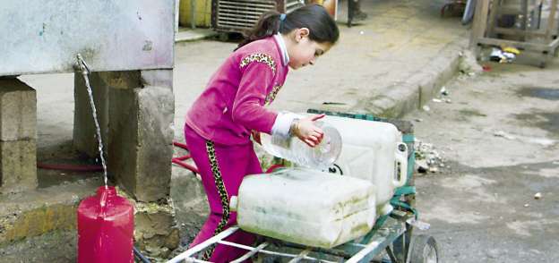 طفلة سورية تجلب المياه لأسرتها فى مدينة «حلب» «أ. ف. ب»