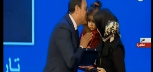 السيسي يقبل طفلة أحد شهداء الشرطة