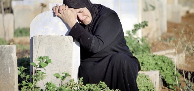 سورية تبكى على قبر أحد أقاربها «أ.ف.ب»