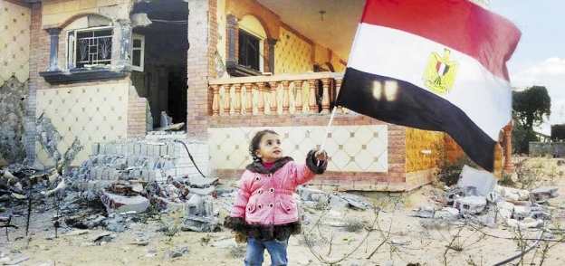 طفلة ترفع علم مصر أمام بيتها فى الشيخ زويد بعد عودتها إليه مع أسرتها